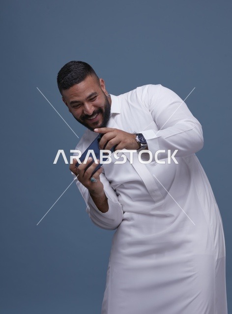 رجل سعودي يلعب ألعاب المحمول على الهاتف الذكي
