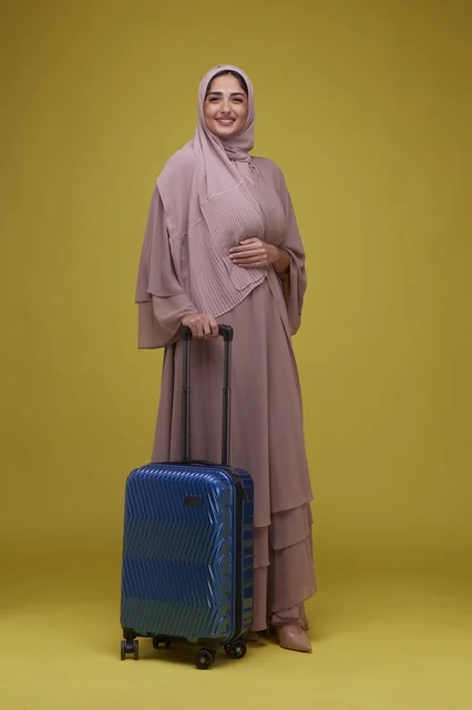 Saudi Woman with Blue Suitcase on Yellow Background