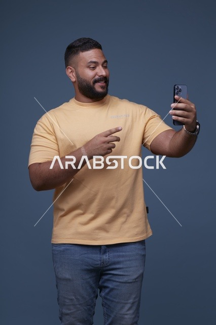 Smiling Saudi Man Using Smartphone in Casual Clothes