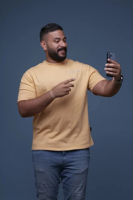 Smiling Saudi Man Using Smartphone in Casual Clothes