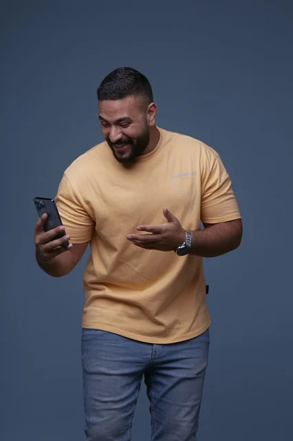 Saudi Man Using Smartphone in Casual Yellow T-shirt