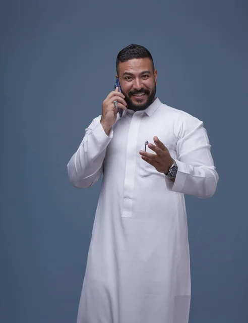 Saudi Man in White Thobe Talking on Smartphone Studio