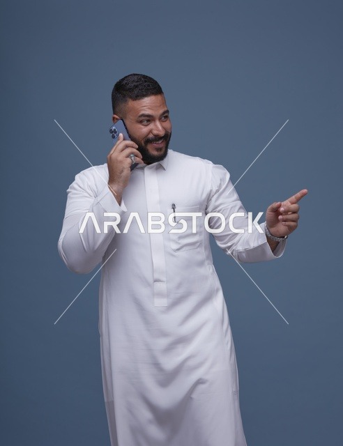 رجل سعودي بالثوب الأبيض يتحدث بالجوال في استوديو