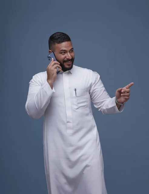 رجل سعودي بالثوب الأبيض يتحدث بالجوال في استوديو