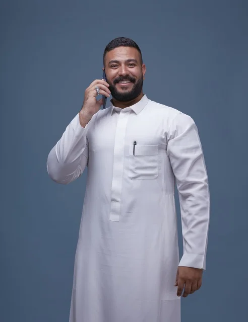 Saudi Man in Thobe Using Smartphone on Blue Background
