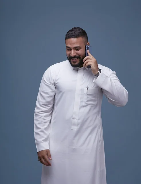 Saudi Man in White Thobe Talking on Smartphone Studio