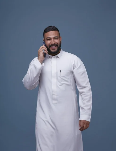 Saudi Man in White Thobe Talking on Smartphone Studio