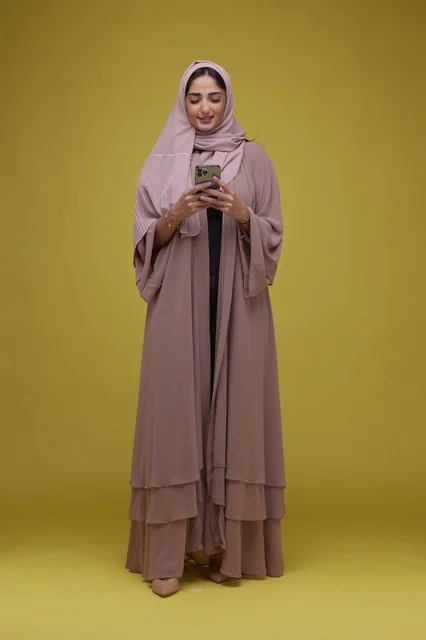 Saudi Woman in Pink Abaya Using Smartphone in Studio