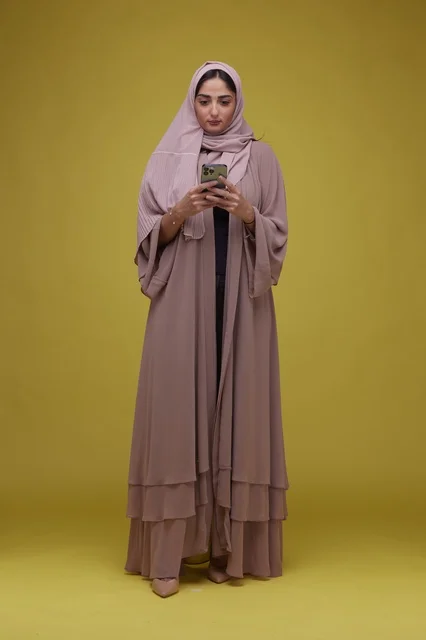 Saudi Woman with Smartphone on Yellow Studio Background