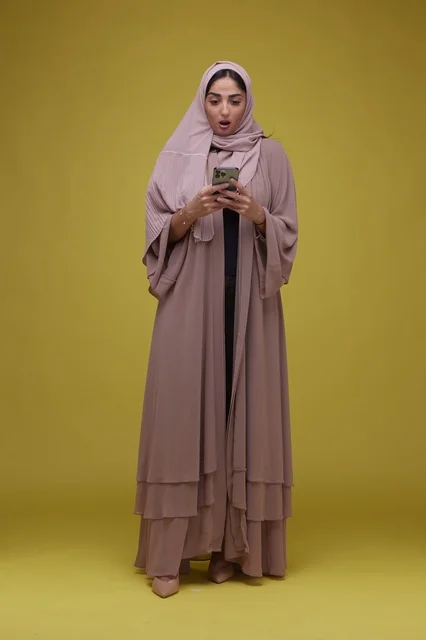 Saudi Woman with Smartphone Shocked Expression in Studio