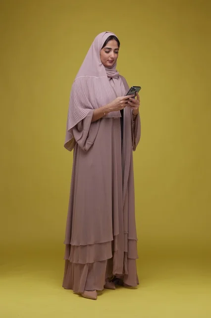 Saudi Woman Using Smartphone in Yellow Studio