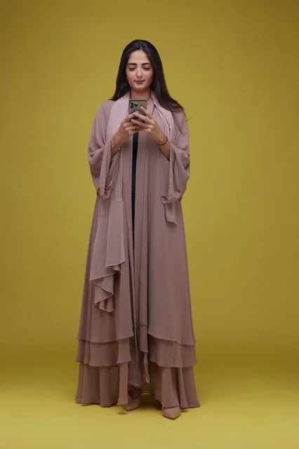 Saudi Woman Using Smartphone Against Yellow Background