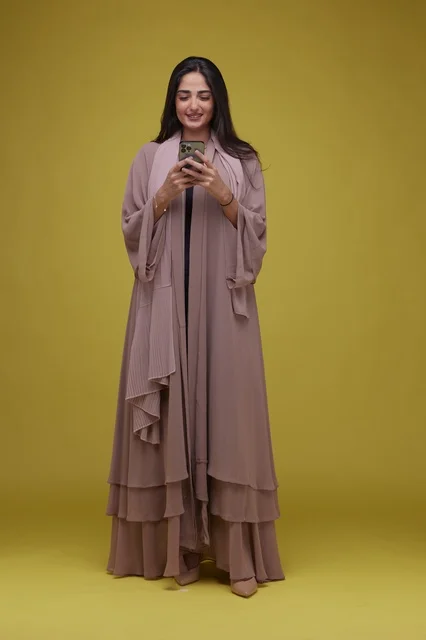 Saudi Woman Using Smartphone on Yellow Background