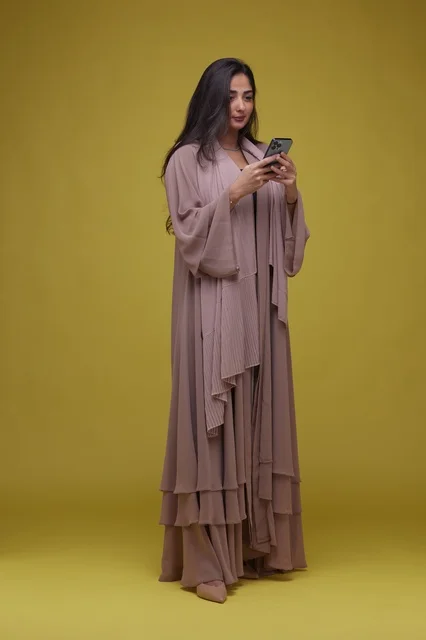 Saudi Woman Using Smartphone on Yellow Background
