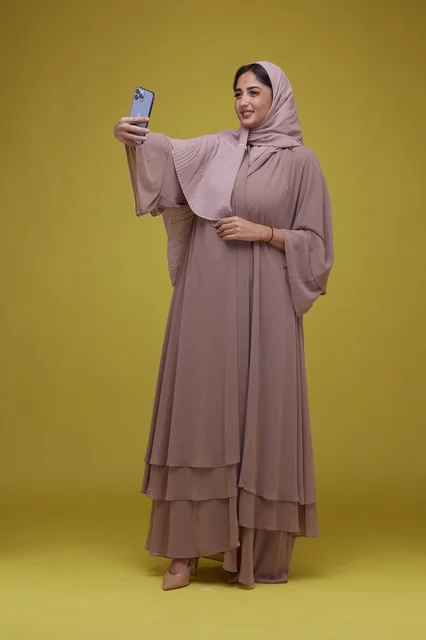 Saudi Woman Taking Selfie in Abaya on Yellow Background