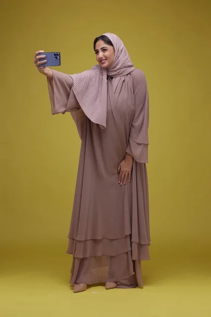 Saudi Woman Taking Selfie in Studio with Yellow Background