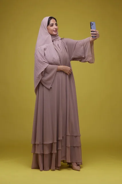 Saudi Woman Taking Selfie in Yellow Studio Full Length