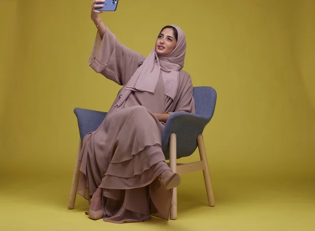 Saudi Woman Taking Selfie on Yellow Background