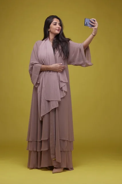 Saudi Woman Taking Selfie with Smartphone on Yellow Background