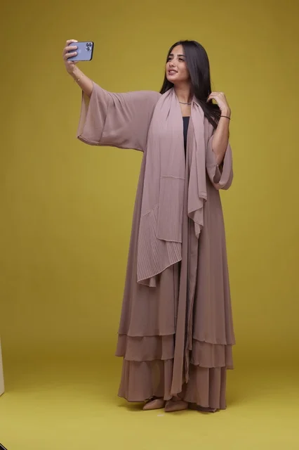 Saudi Woman Taking Smartphone Selfie on Yellow Background