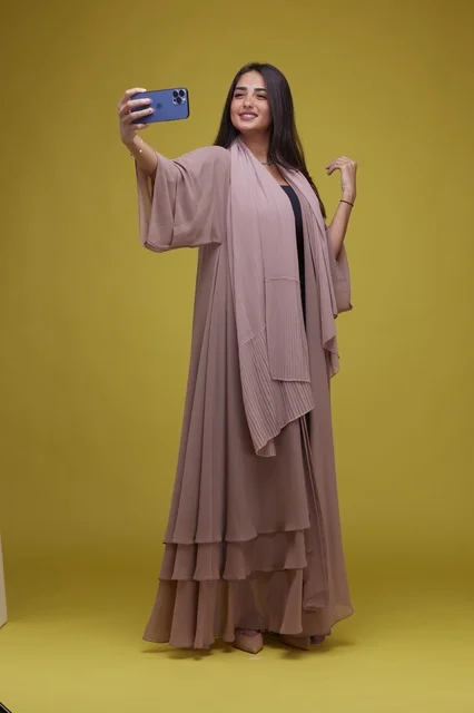 Saudi Woman Taking Selfie on Smartphone Yellow Background Saudi Woman Taking Selfie on Smartphone Yellow Background