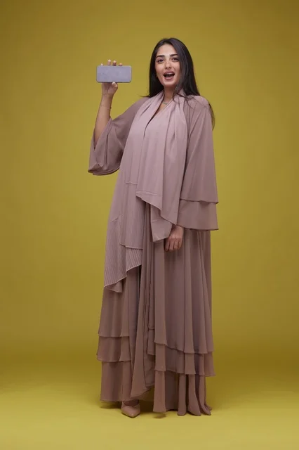 Saudi Woman Holding Smartphone Screen on Yellow Background