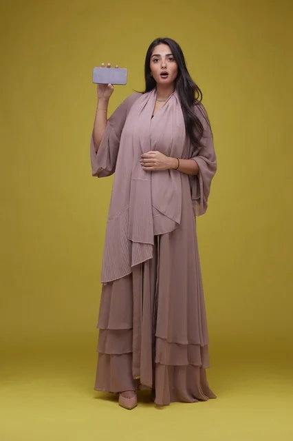 Saudi Woman Holding Smartphone on Yellow Background