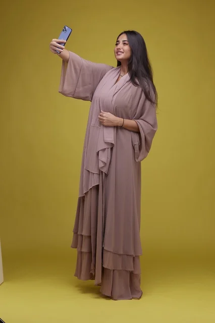 Saudi Woman in Abaya Taking Selfie Yellow Background