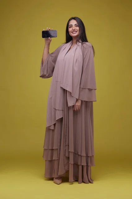 Saudi Woman Holding Smartphone on Yellow Background