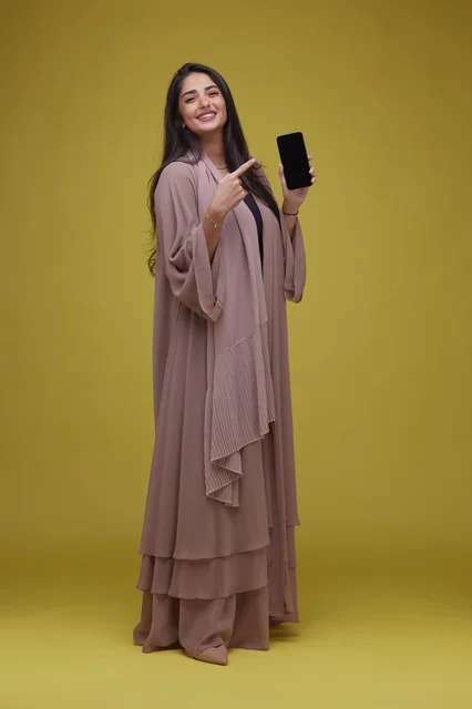 Saudi Woman with Smartphone on Yellow Background