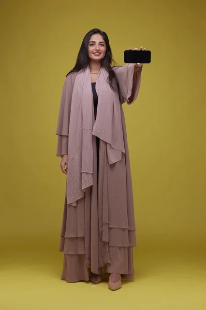 Saudi Woman Holding Smartphone on Yellow Background