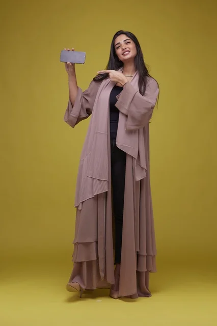 Saudi Woman Holding Smartphone on Yellow Background