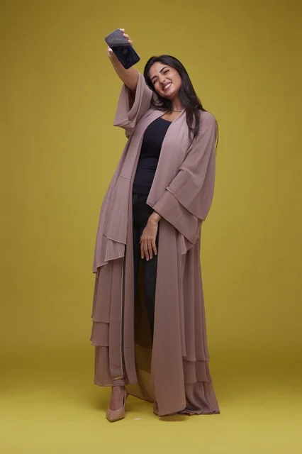Saudi Woman with Smartphone on Yellow Studio Background