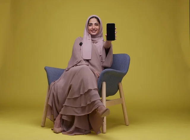 Saudi Woman Holding Smartphone with Blank Screen