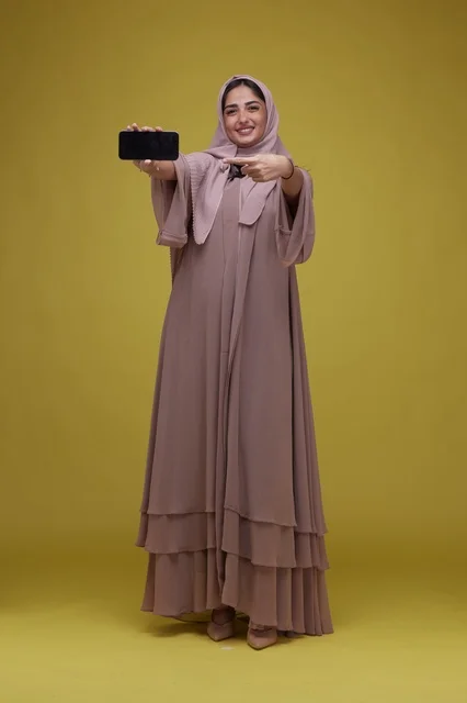 Saudi Woman with Blank Phone Screen on Yellow Background