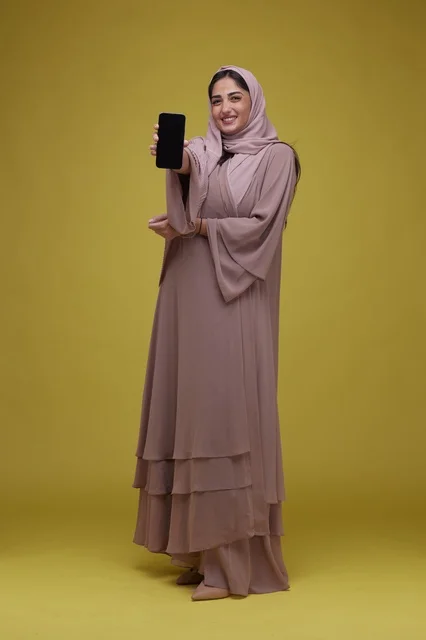 امرأة سعودية تحمل هاتف ذكي بشاشة فارغة