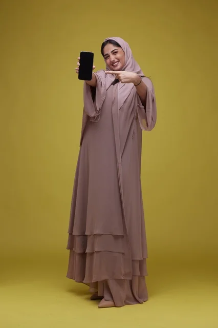 Smiling Saudi Woman Presenting Blank Smartphone Screen