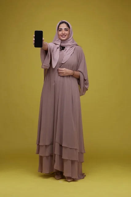 Saudi Woman Holding Blank Smartphone Screen Yellow Background