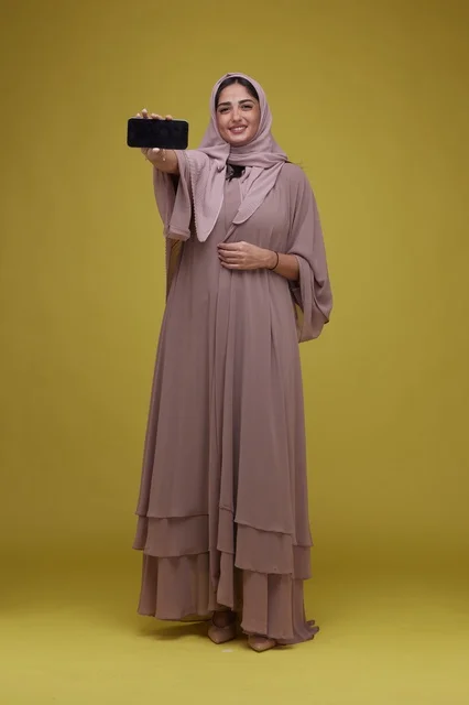 امرأة سعودية تعرض شاشة هاتف ذكي فارغة بالاستوديو