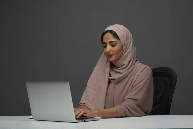 Saudi Woman Working on Laptop in Modern Office