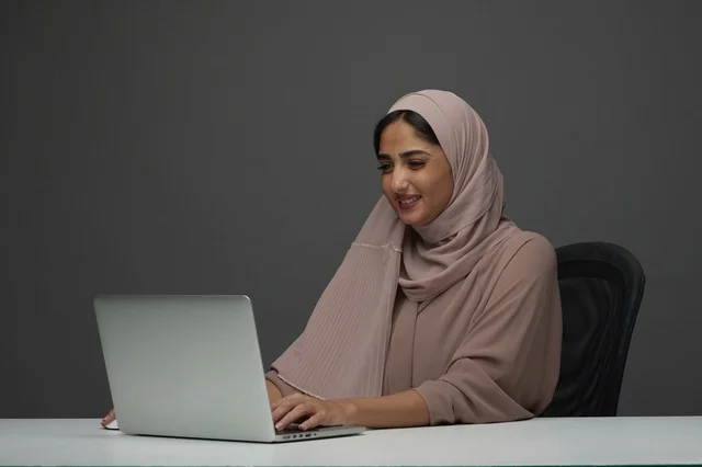 Saudi Woman Working on Laptop at Modern Office Desk