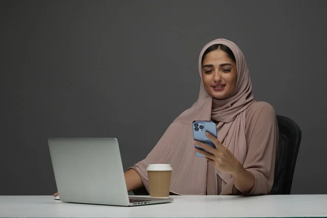 Saudi Businesswoman at Office Desk with Laptop and Phone