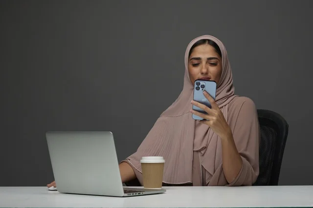سيدة أعمال سعودية تستخدم الهاتف الذكي في المكتب