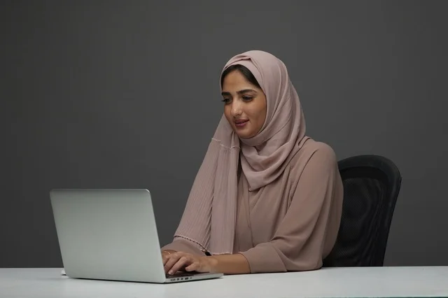 Saudi Woman Working on Laptop in Modern Office Environment