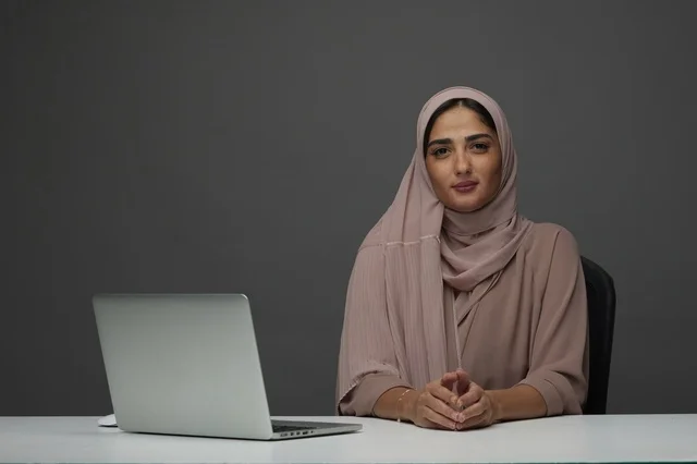 سيدة أعمال سعودية مع لابتوب في المكتب