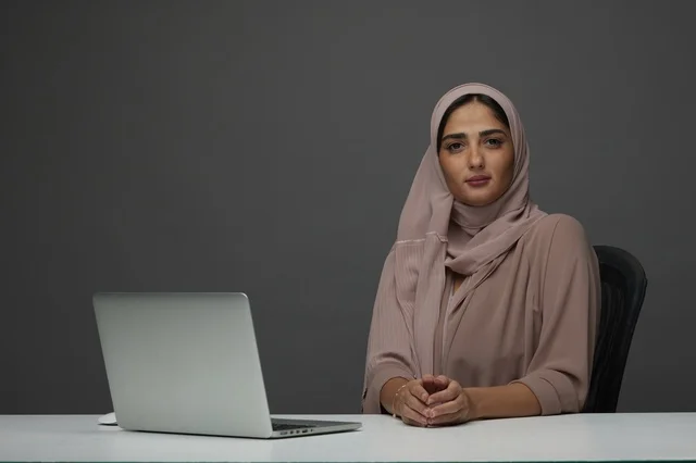 Saudi Businesswoman with Laptop at Desk Studio Portrait