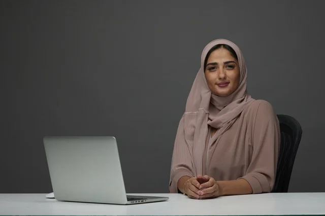 Smiling Saudi Businesswoman with Laptop at Office Desk