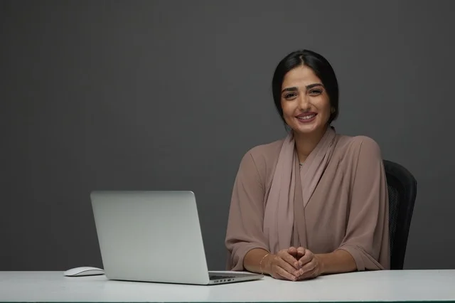 سيدة أعمال سعودية مع لابتوب بخلفية استوديو رمادية سيدة أعمال سعودية مع لابتوب بخلفية استوديو رمادية