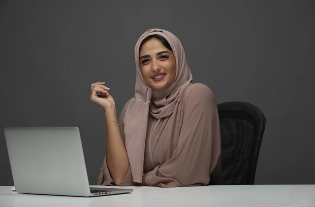 Smiling Saudi Businesswoman with Laptop at Office Desk