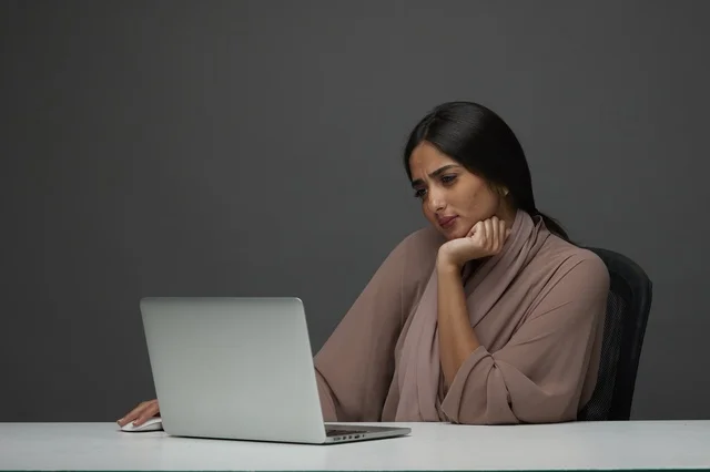 سيدة أعمال سعودية تعمل على اللابتوب في مكتب عصري
